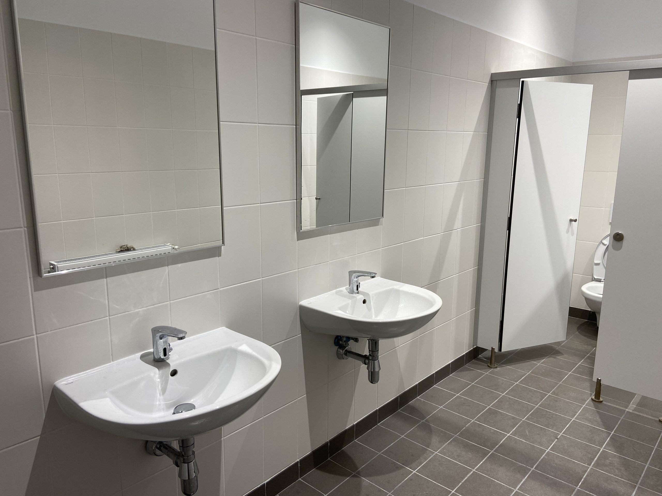 Lavoare și cabine sanitare în grupul sanitar al proiectului Allianso SE4/SE5.